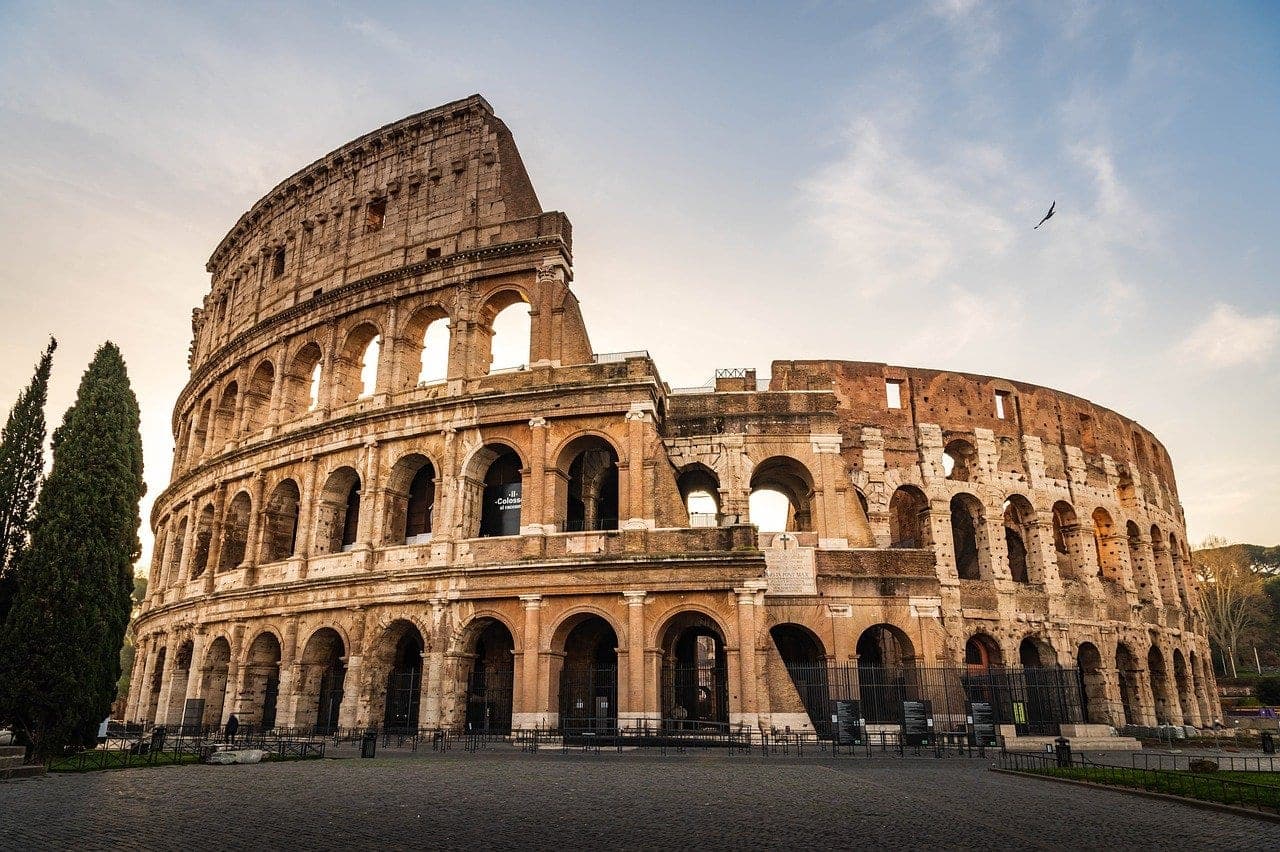 Rome Colosseum exterior with arches and ancient stone glowing in golden evening light